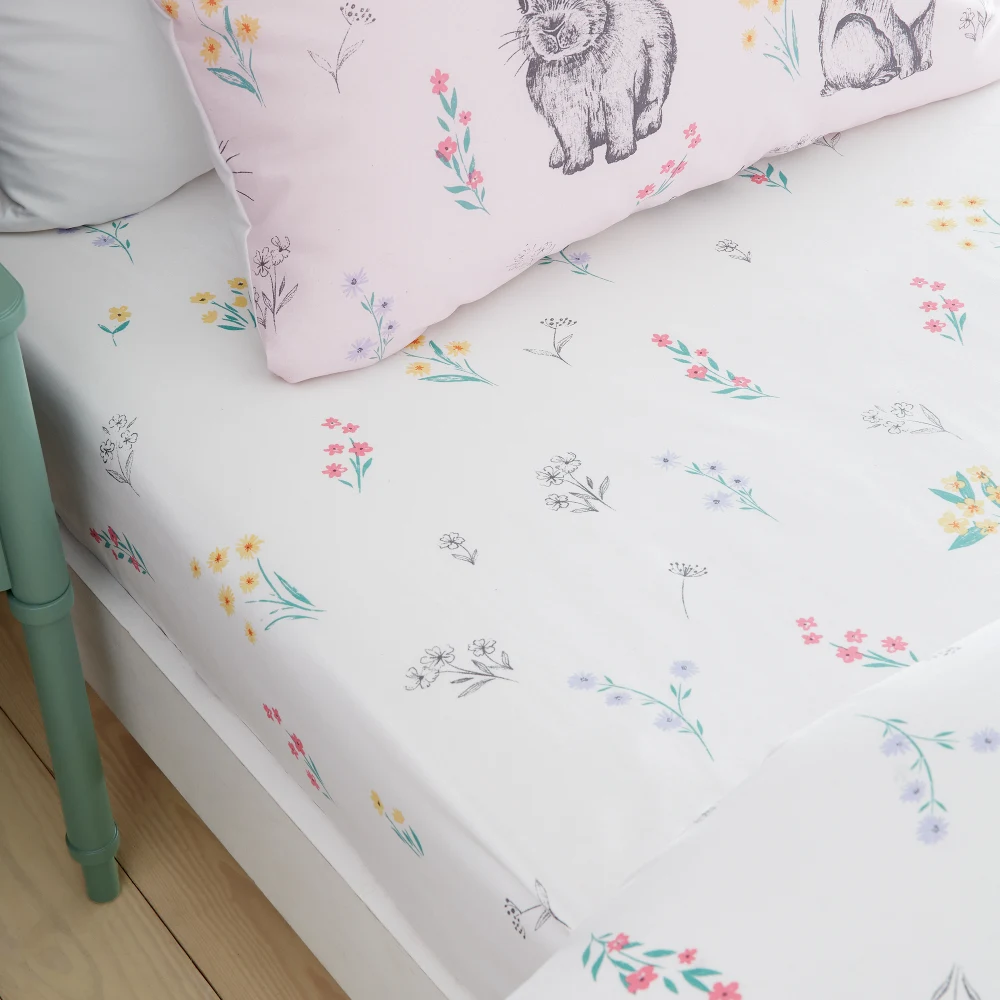 This Bunny Tails Ditsy Flowers Toddler Fitted Sheet, from Catherine Lansfield features a pretty floral design on a white background.